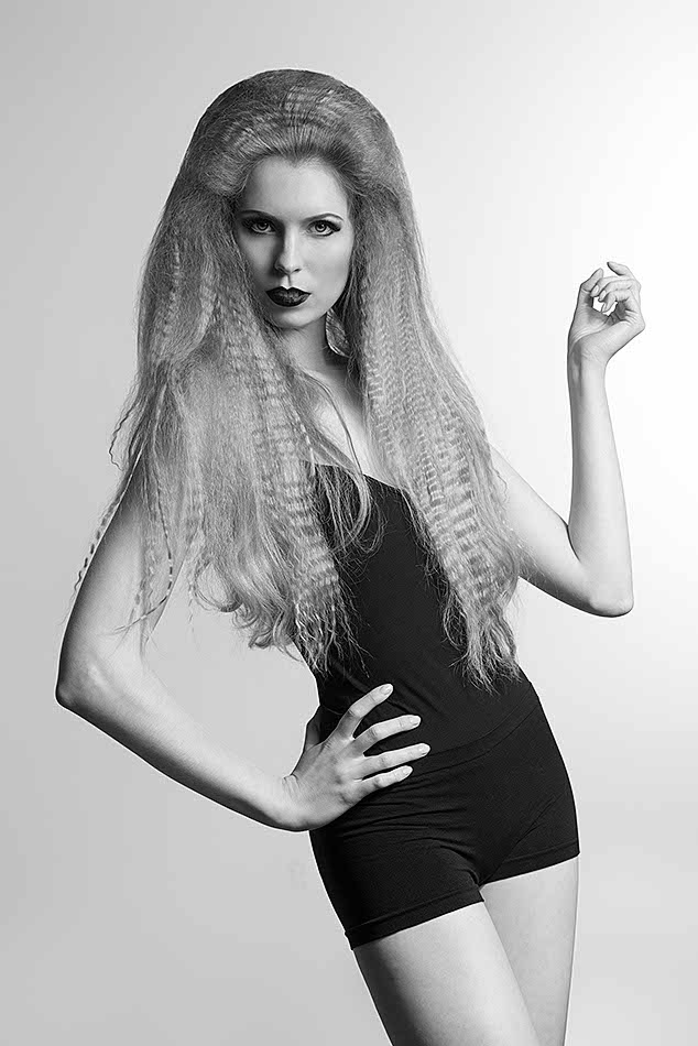 fashion girl with long creative blonde hair-style and black sexy clothes posing with dark strong make-up