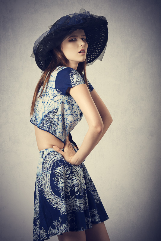 pretty girl in fashion pose with lovely summer style and hat, wearing skirt and top and looking in camera
