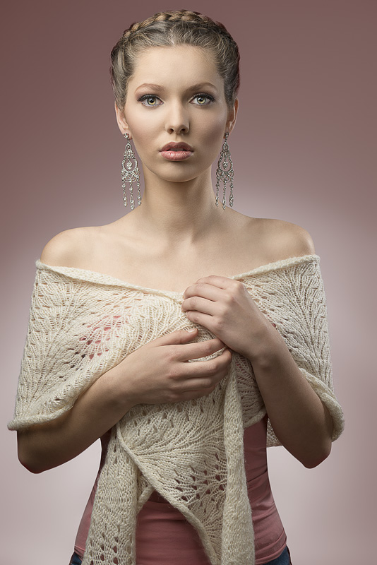 portrait of sensual brunette woman with fashion elegant style, creative hair-style and precious earrings. Covering by wool shawl